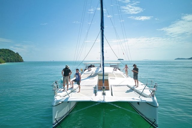 a bow view of Nyami with 6 guests on deck enjoying the views of nearby islands off phuket